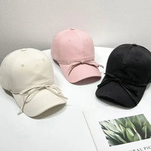 Three bow solid color baseball caps in cream, pink, black