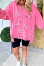 Pink oversized bow v-neck sweatshirt with sequined bow appliqués designed for machine wash cold care