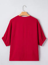 Red braided detail half sleeve blouse with puffed sleeves and round neckline on wooden hanger