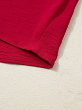 A vibrant red half sleeve blouse with braided detail and textured soft crinkled fabric and neatly stitched edges