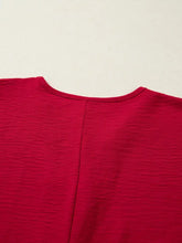 A vibrant red textured cotton half sleeve blouse with braided detail and subtle vertical seam accents