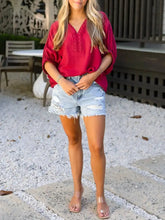 A vibrant red half sleeve blouse with braided detail, loose fit, v-neck, and delicate lace along the neckline