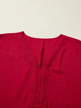 A vibrant red half sleeve blouse featuring a v-neckline and intricate braided detail along the front
