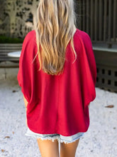 A vibrant red half sleeve blouse with braided detail, wide sleeves, and a loose, relaxed fit