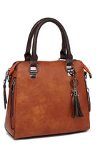 Brown leather bag set with dark handles and tassel charm