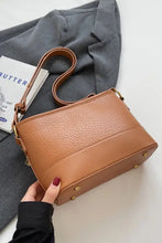 Tan leather shoulder bag with gold hardware and structured shape