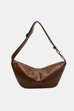 Brown leather sling bag with crescent shape and adjustable strap