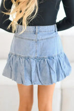 Light blue denim mini skirt featuring a flared ruffled bubble hem detail in soft denim fabric