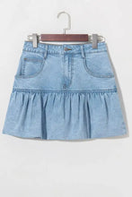 Light blue denim mini skirt with bubble hem ruffle and front pockets made of denim material