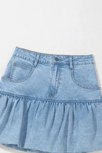 Light blue denim mini skirt with bubble hem ruffle and front pockets made from soft denim material