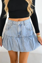 Light-wash denim mini skirt with bubble hem ruffle and front pockets in light-wash denim material