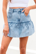 Bubble hem denim mini skirt in light-wash denim featuring a ruffled hem and front pockets for stylish wear