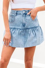 Light-wash denim mini skirt with bubble hem ruffle and front pockets in a casual denim mini style