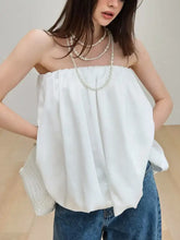 White off-the-shoulder bubble hem tube top with soft flowing fabric and gentle front pleats for elegant wear