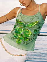 A light green butterfly embellished slim fit cami with sequins and floral accents featuring a large shimmering butterfly design