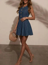Blue denim sleeveless dress with gold-tone buttons down the front and a flared skirt in a sleeveless denim style