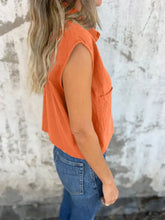 Orange sleeveless button-down cap sleeve shirt with single chest pocket and relaxed fit for casual wear