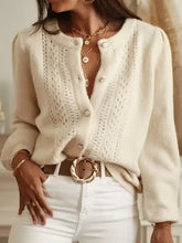 Cream-colored eyelet cardigan with openwork design and cable-knit texture