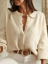 Cream-colored eyelet cardigan with cable-knit texture and buttons