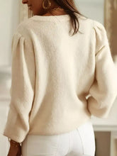 Cream-colored eyelet cardigan with openwork design and puffed sleeves
