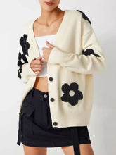 Cream-colored floral applique knit cardigan with black flowers on shoulders
