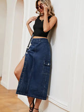 Button down midi denim skirt in blue with mid-thigh length, side slit, cargo pockets, and button closures