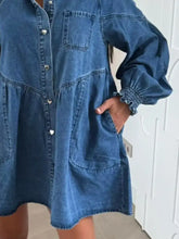 Button down mini denim dress in blue with heart-shaped silver buttons, smocked cuffs, and front pockets