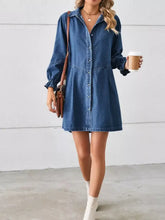 A womens medium-wash denim dress with button front closure long sleeves and ruffle cuff details machine wash safe