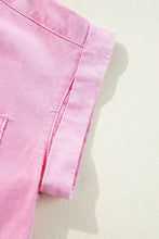 Pink short sleeve denim dress featuring button down front and visible front pocket with rolled-up sleeves