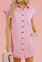 A soft pink short sleeve denim dress with rolled sleeves front button closure and two chest pockets