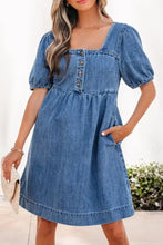 A medium-wash denim dress with puffed short sleeves, square neckline, and front button closure, perfect as a puff sleeve denim dress