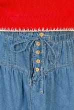 Blue denim skirt with button-front closure and matching drawstring tie featuring a ruffle hem denim design