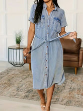 Light blue short sleeve denim dress with button front and tied waist belt in soft denim fabric