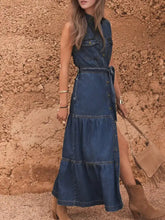A mid-blue sleeveless denim dress with button front design and tiered skirt perfect as a stylish denim dress