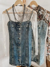 Blue denim dress with button front design and sheer white lace overlay featuring a square neck denim style