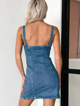 Blue denim mini dress with a fitted silhouette and backless design featuring sweetheart neckline and button front detail