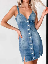 A fitted blue denim mini dress with button front closure, sweetheart neckline, and side slit