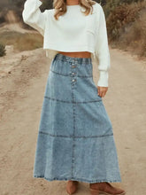 Button-front tiered maxi denim skirt in blue with a-line shape and subtle horizontal seam detailing