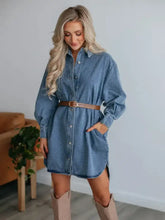 A denim dress featuring a button-up front, collared neck long sleeves, and a belted waist in blue denim
