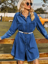 Blue raw hem denim dress with button up collar, frayed hem, white belt, and long sleeve length detail