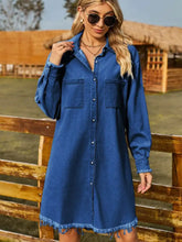 Blue denim dress with a button-up collared neck, raw hem, and frayed sleeve length cuffs