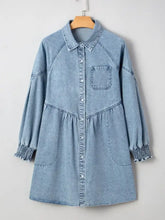 Light blue denim shirt dress with long sleeves smocked cuffs and button-front closure in denim fabric