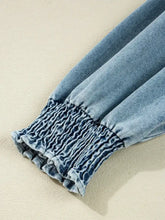Light-wash denim shirt dress sleeve with gathered elasticated smocked cuff detail in a button-up denim shirt dress