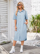 Light blue denim dress with dropped shoulder, short sleeves, front pocket, and button-down design