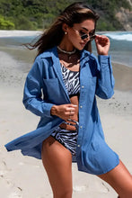 Blue long-sleeve longline shirt with breast pockets over zebra swimsuit