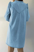 Light blue denim dress with notched long sleeve and ruffled shoulders showing v-shaped embroidered back detail machine wash cold