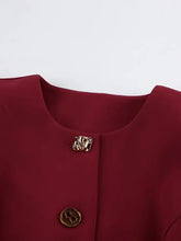 Gold shell-like button on burgundy Button Up Peplum Blazer fabric