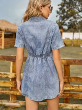 A light-wash button up short sleeve mini denim dress with collar and elastic waistband in denim fabric