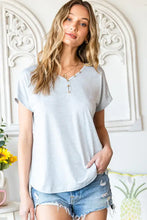 Light blue short-sleeved V-neck henley tee with rolled cuffs and distressed denim shorts