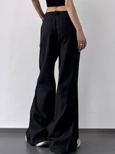 Black wide leg high waist trousers with a sleek tailored fit and subtle front button closure